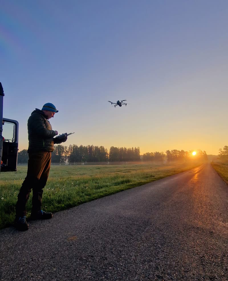 Pilot startet bei Sonnenaufgang die Wärmebilddrohne am Feldweg